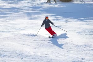 Energetic skier carving through fresh snow on a sunny winter day.
