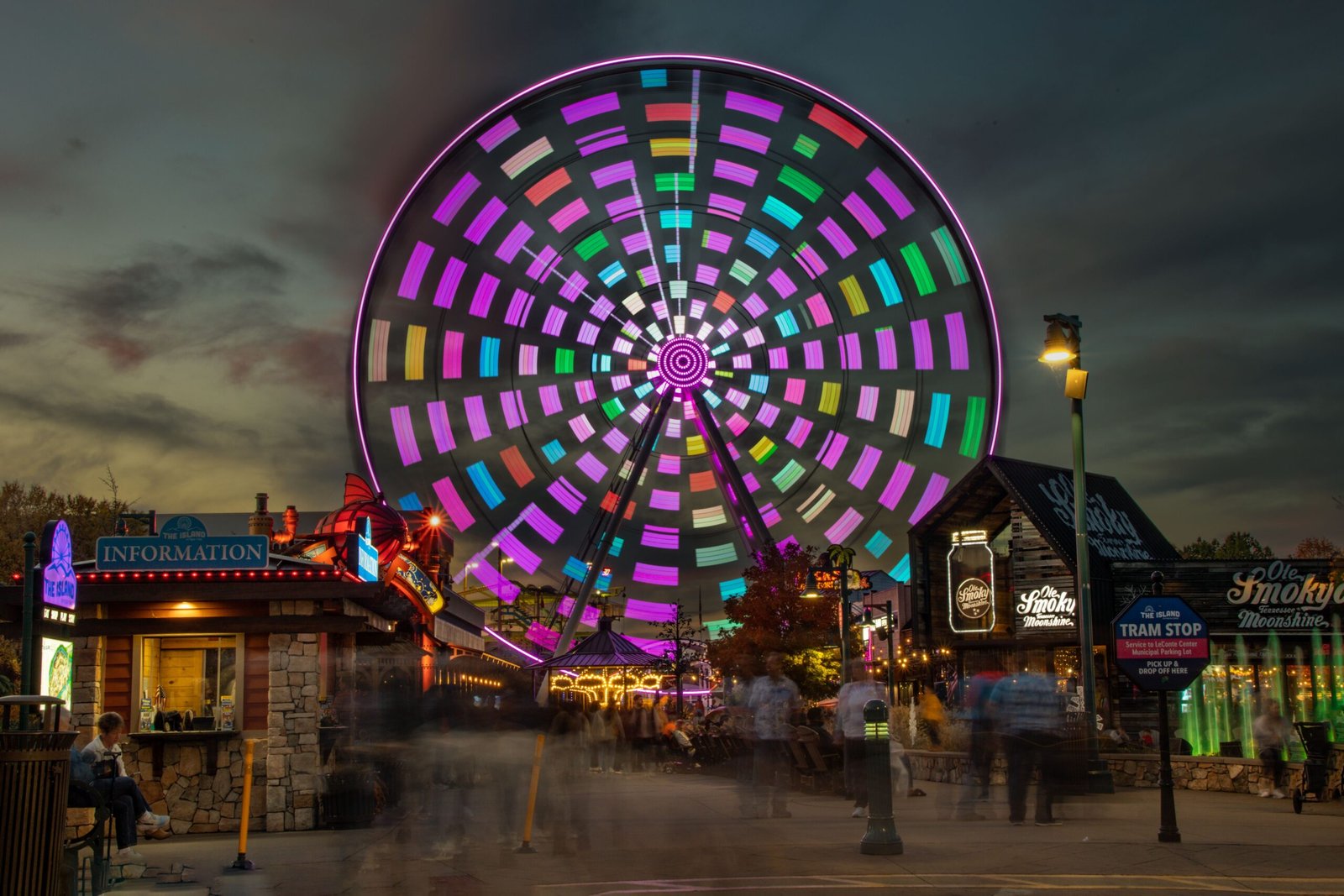 Colorful Ferris wheel glowing at night in Pigeon Forge amusement park.